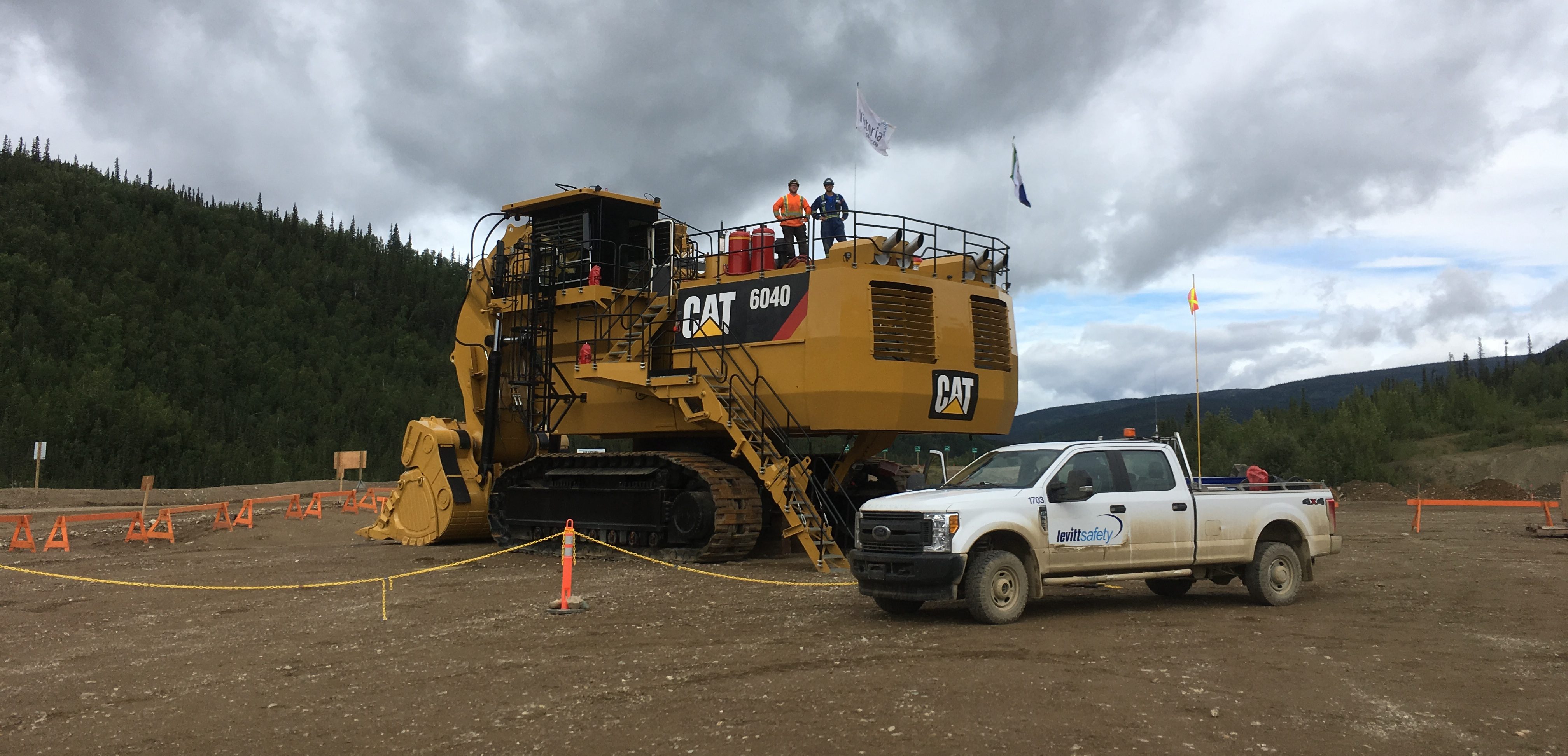 levitt-safety worker standing on top of CAT 6040 heavy equipment