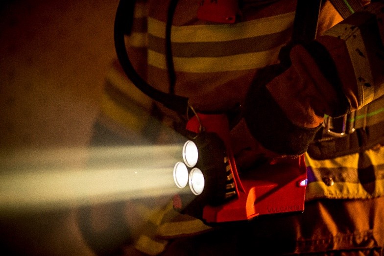 close up shot of vulcan 180 flashlight being held by a firefighter's hip