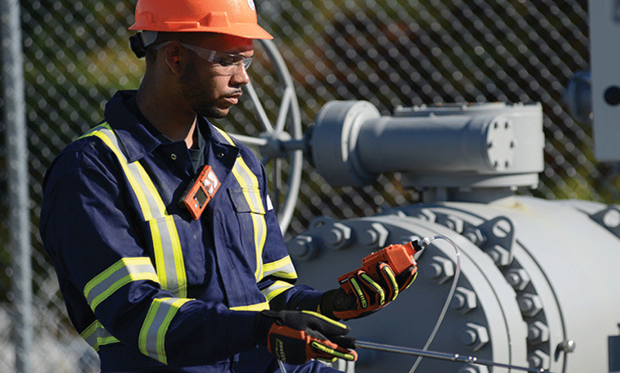 man wearing ventis gas monitor while taking a gas reading