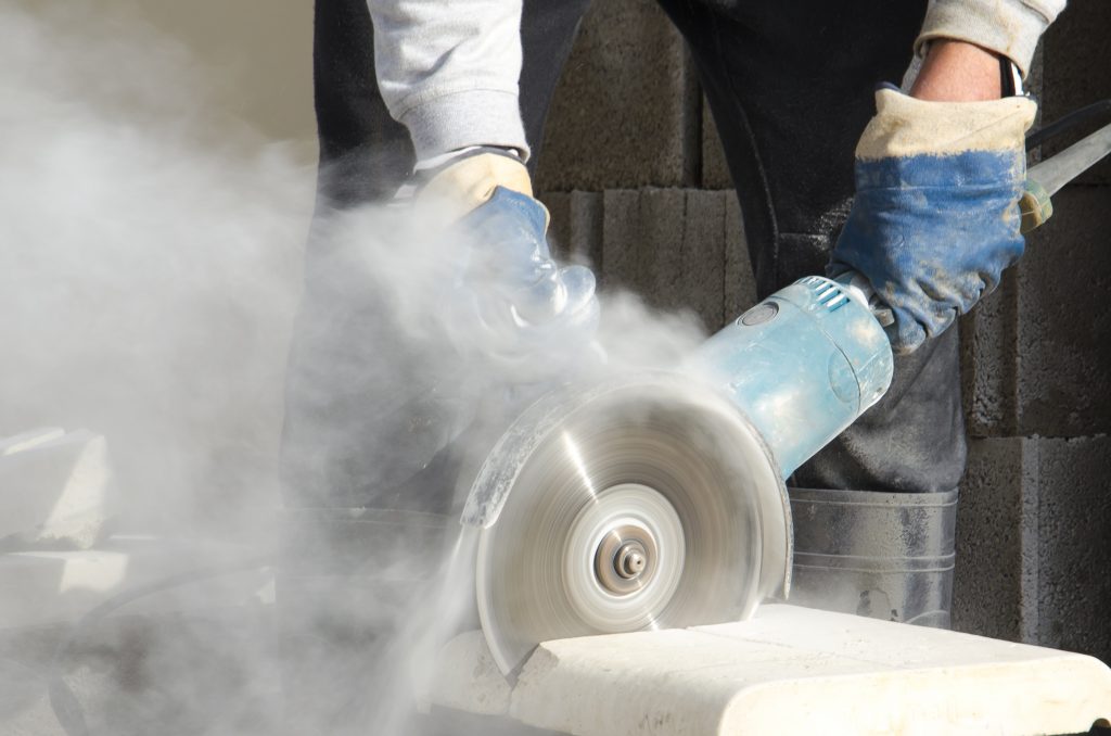 Worker cutting stone with grinder
