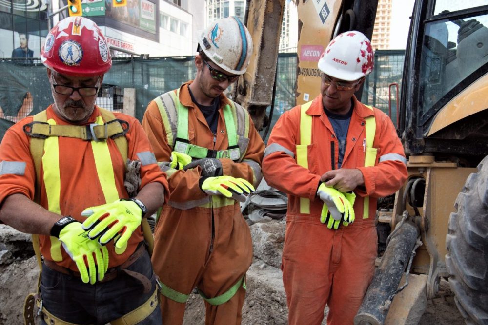 Construction workers trying on gloves