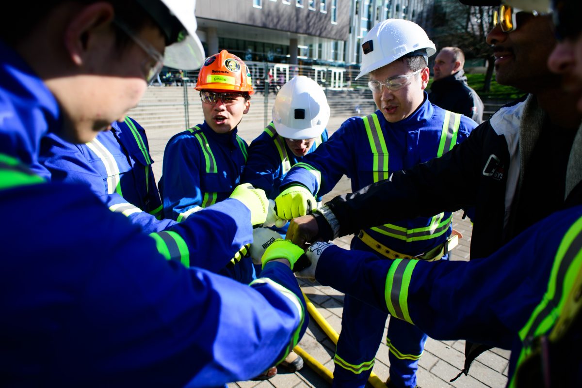 group of mining students fist bumping during the Canadian International Student Mine Rescue Competition