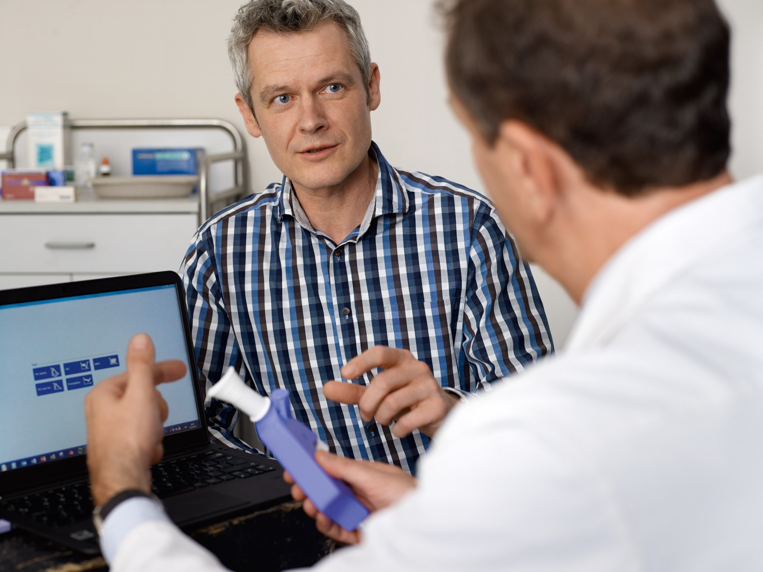 patient speaking with clinician who is hold a spirometer