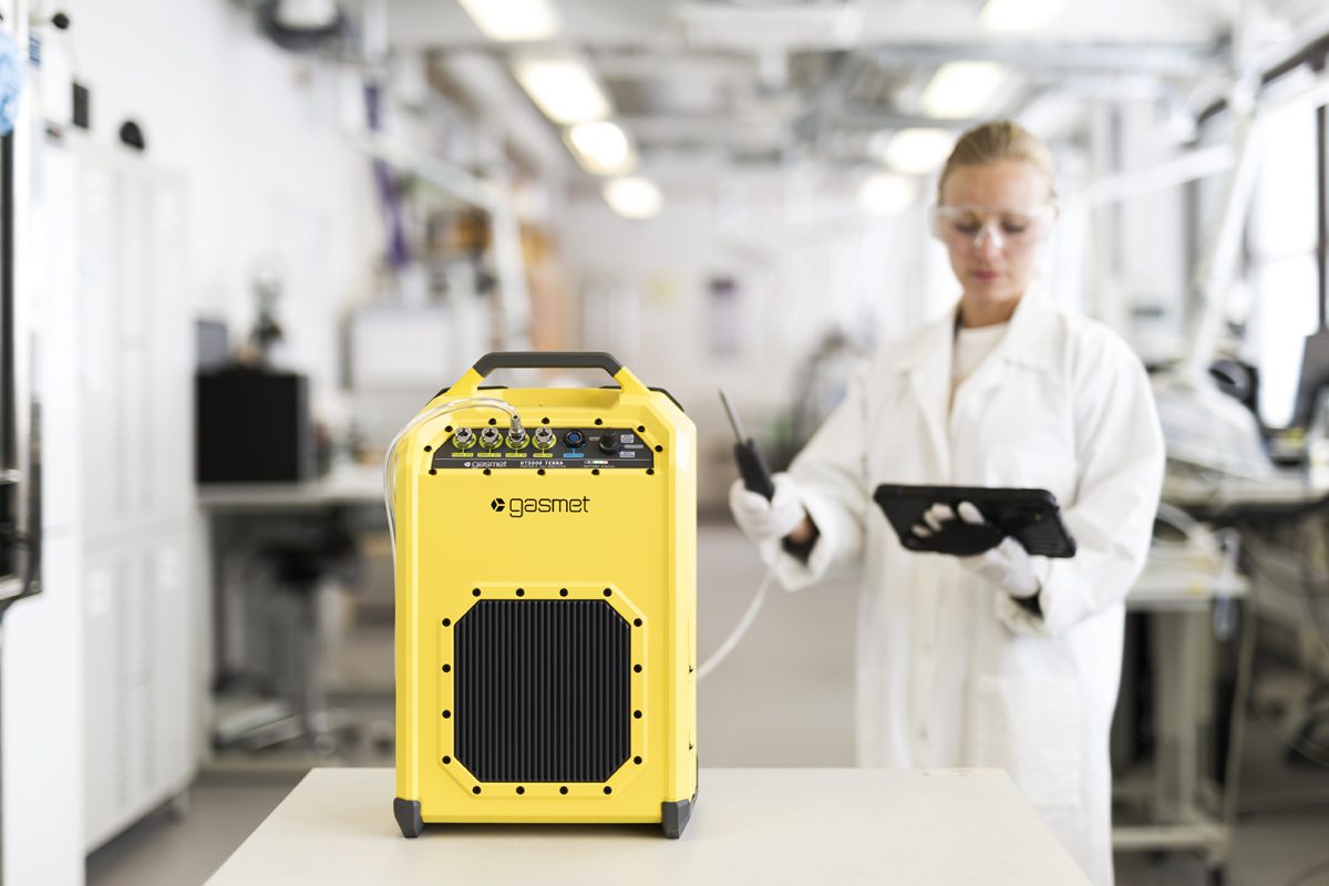 Scientist in laboratory using Gasmet GT 5000 while staring at an ipad