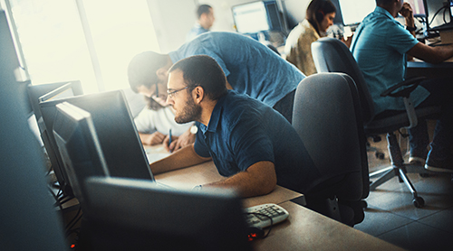 Customer service specialist sitting in front of a computer screen wearing blue light filtering glasses