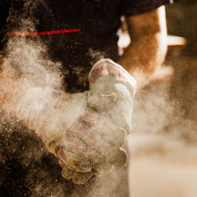 Gloved hands shaking off dust