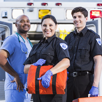 EMS staff, ER doctor standing beside two EMS workers