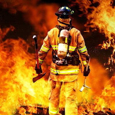 Fire fighter walking towards a fire